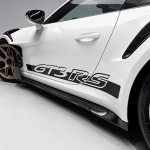 Dry carbon side skirts and side skirt air knife along the flank of a Porsche 911 GT3 RS (992)