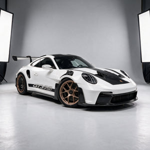 Porsche 911 GT3 RS (992) in white with bronze wheels and rear carbon aero discs, wearing the full Carbon District dry carbon body kit, front three-quarter in the studio