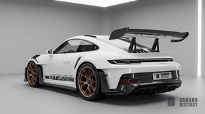 Porsche 911 GT3 RS (992) dry carbon fibre body kit, rear three-quarter view showing wing end plates, rear bumper lower section and diffuser